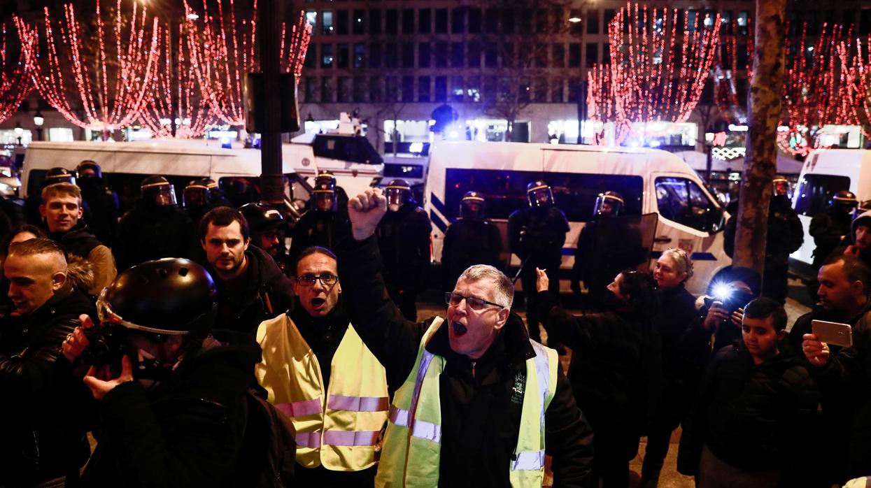 Los manifestantes antigubernamentales "chaleco amarillo" (gilets jaunes) protestan en los Campos Elíseos en el centro de París