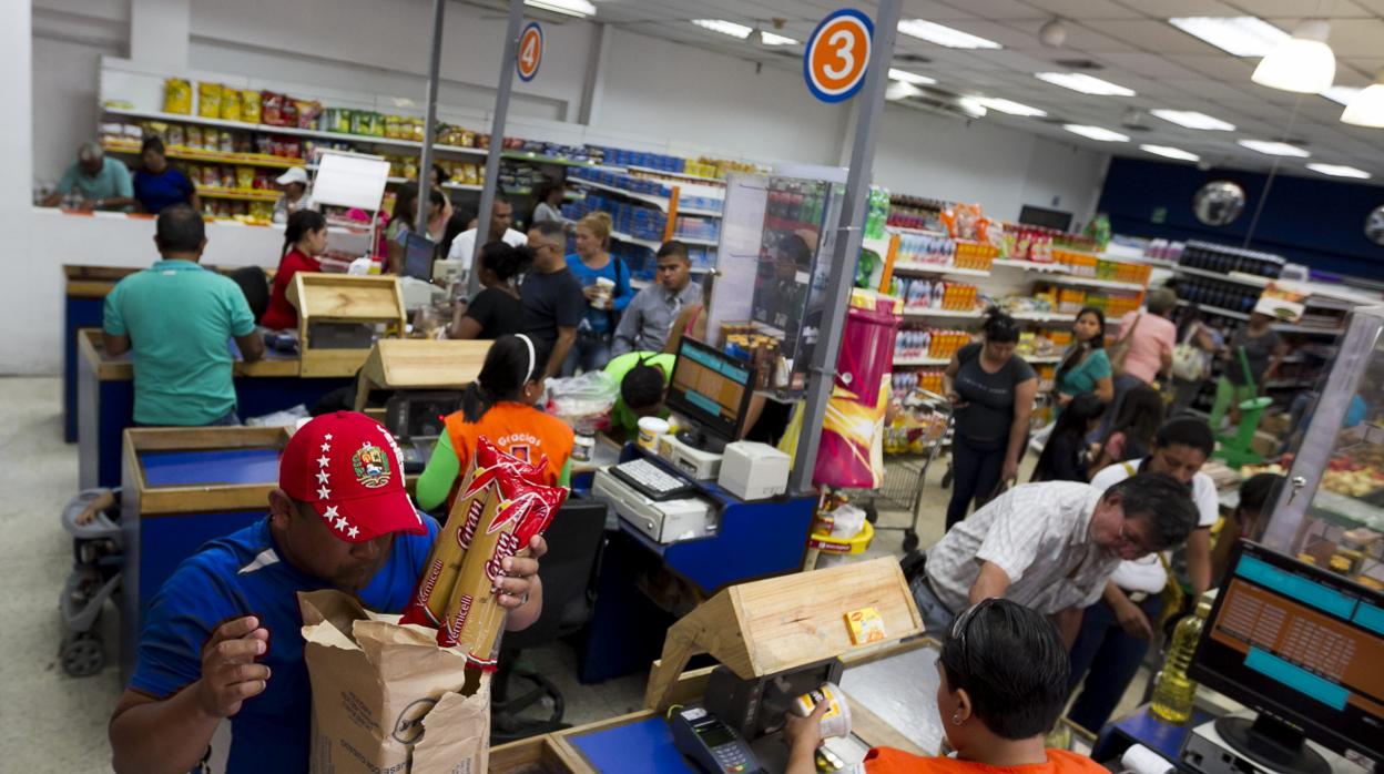 Un grupo de personas hacen las compras dentro de un supermercado en Caracas