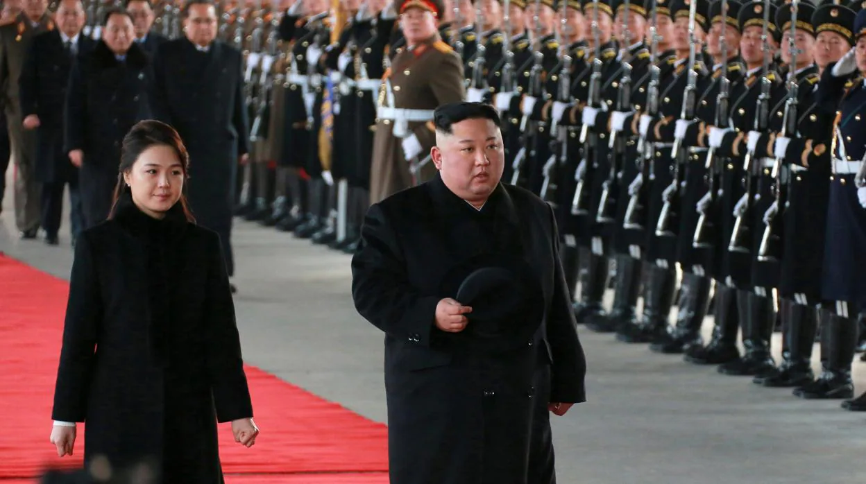 Kim Jong Un y su esposa, Ri Sol-ju , mientras pasan revista a una guardia de honor durante su salida hacia China