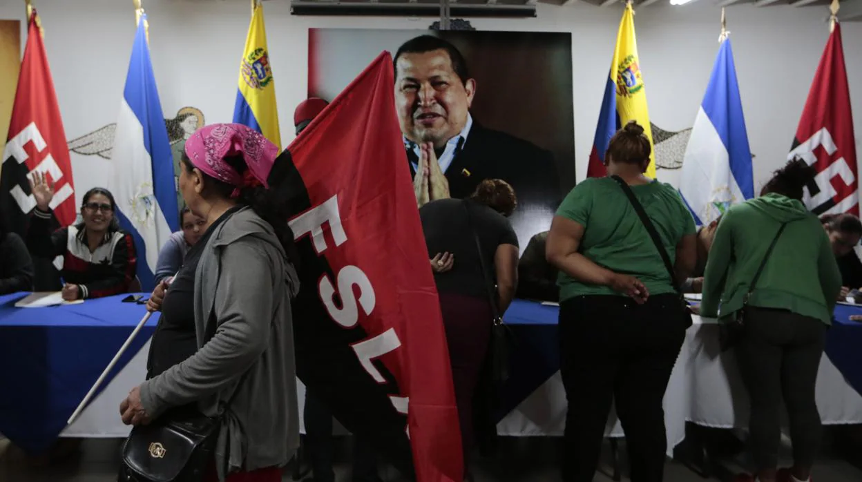 Seguidores del Frente Sandinista firman su respaldo a Nicolás Maduro ante un retrato de Hugo Chávez