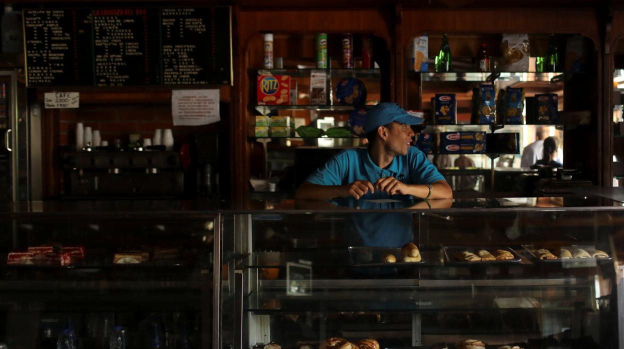 Un trabajacdor, en el interior de una panadería, sin luz, en Caracas