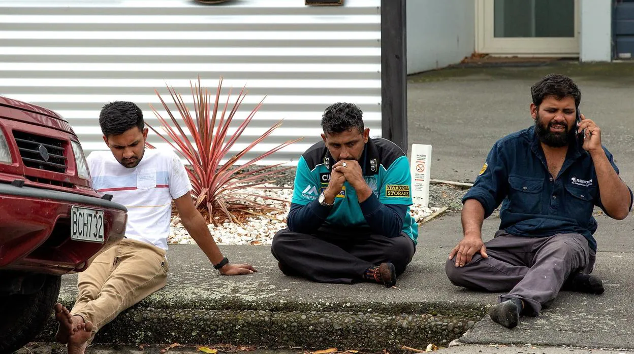 Personas se sientan en una acera tras el atentado en Masjid Al Noor , en Christchurch (Nueva Zelanda)