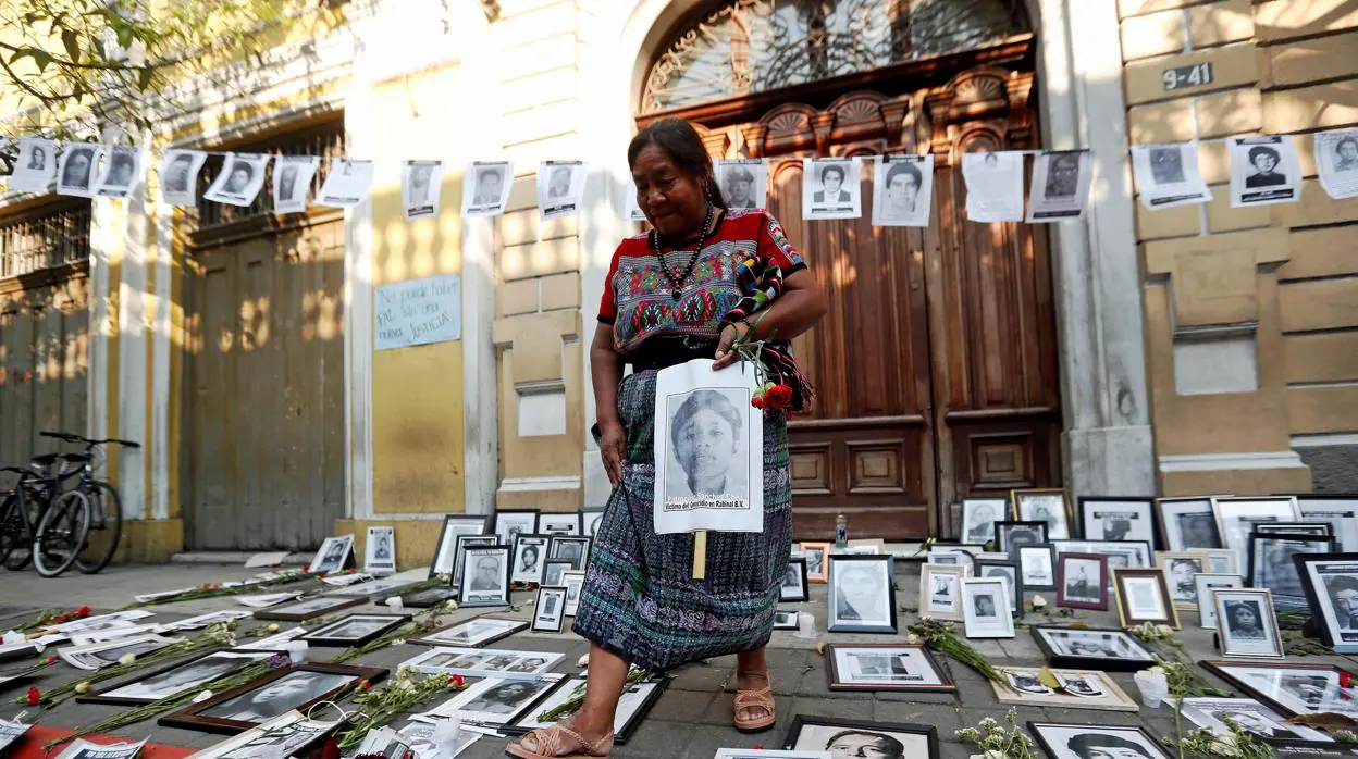 La activista indígena Rosalina, Tuyuc particpa, rodeada de fotografías de víctimas de la guerra civil, en una protesta frente al Congreso de Guatemala