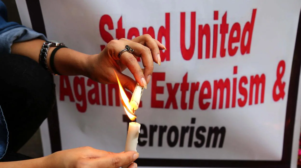 Varias personas enciden velas para honrar a las nueve víctimas paquistaníes que murieron en el atentado de Crhistchurch