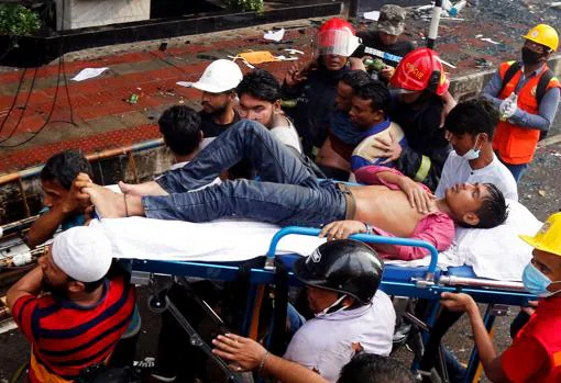 Miembros del cuerpo de bomberos de Bangladesh rescatan a varias personas que se hallaban en el edificio