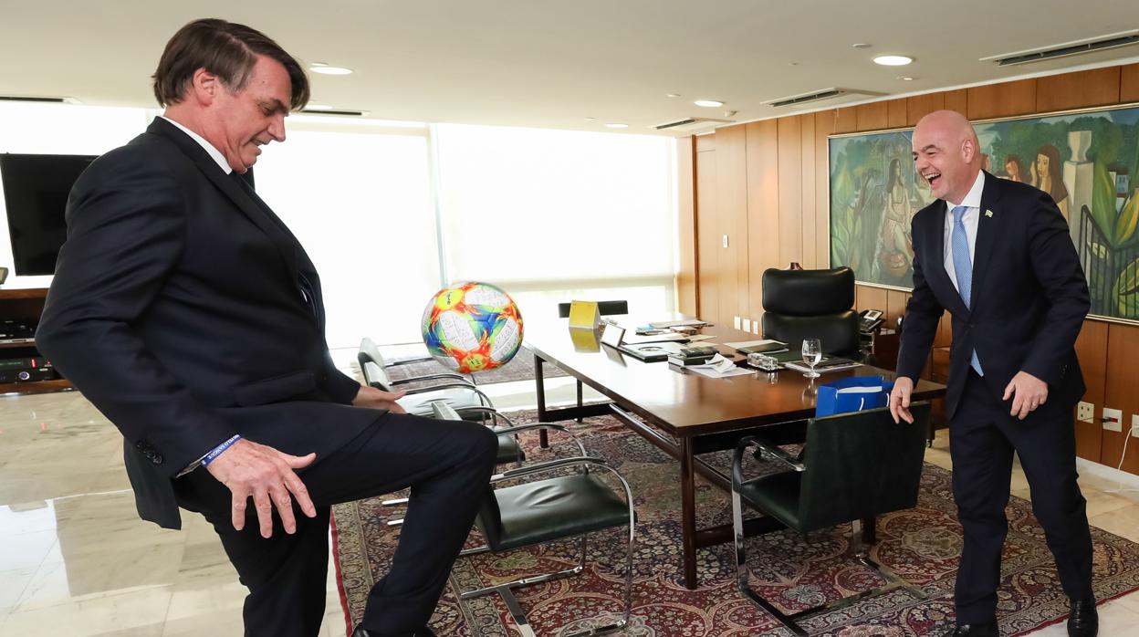 El presidente Bolsonaro juega al balón con el presidente de la FIFA, Gianni Infantino, durante un encuentro en Brasilia ilia,