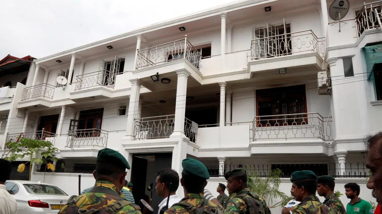 Miembros de las fuerzas de seguridad vigilan en el lugar, donde tres compañeros fueron asesinados, durante el registro de una casa