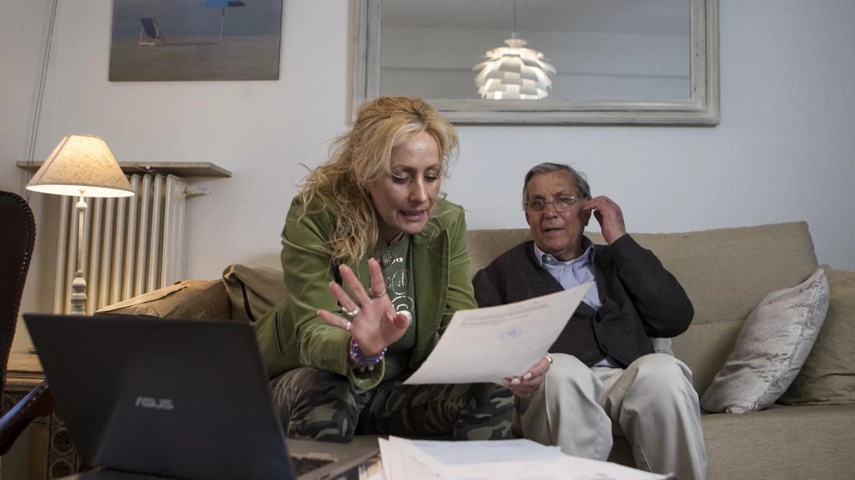 Elena Cáceres y su padre, Francisco, revisan documentos sobre los bienes confiscados a un pariente