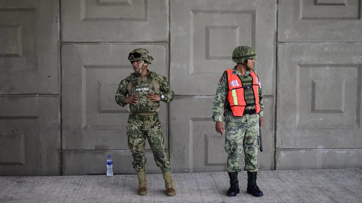 Un agente de la Marina y la Policía Militar se encuentran en un puesto de control en busca de personas sin documentos en las afueras de Tapachula, estado de Chiapas