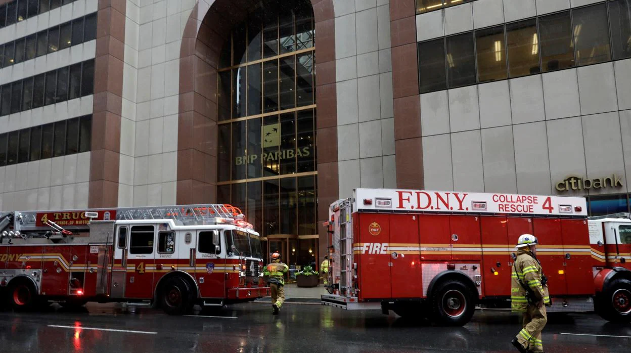 Bomberos llegan al edificio con el que un helicóptero se estrelló, este lunes, en el centro de Manhattan