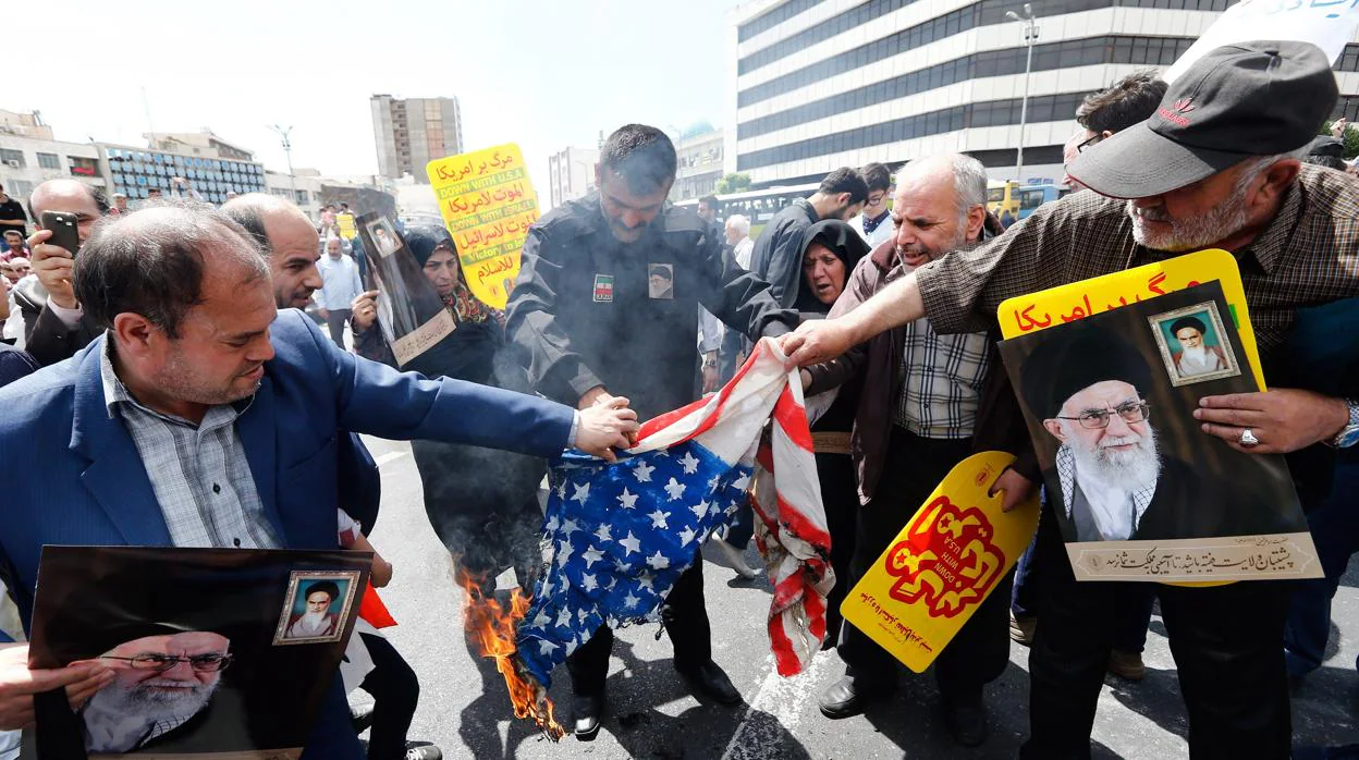 Manifestantes iraníes queman una bandera estadounidense durante una protesta en mayo