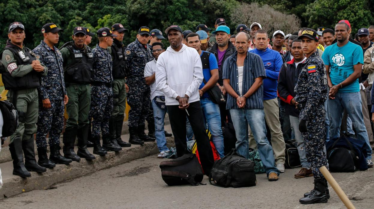 Efectivos de la Policía colombiana custodian a los ciudadanos liberados en la frontera entre ambos países