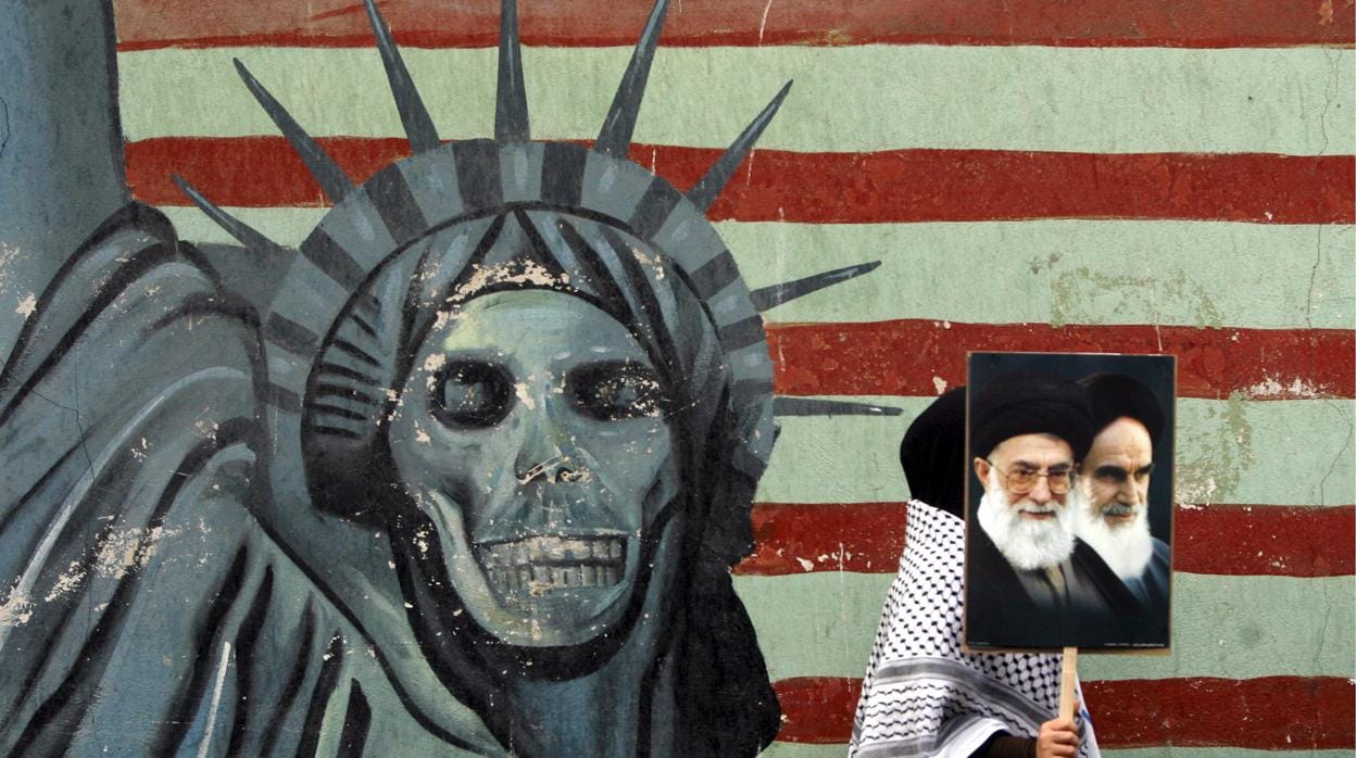 Una persona pasa junto a un mural antiestadounidense en Teherán