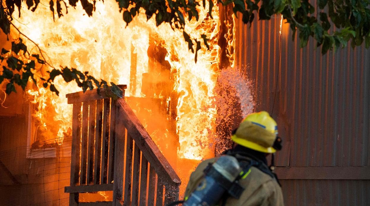 Los bomberos tratan de apagar un incendio en un parque de casas móviles en Ridgecrest, cerca del epicentro