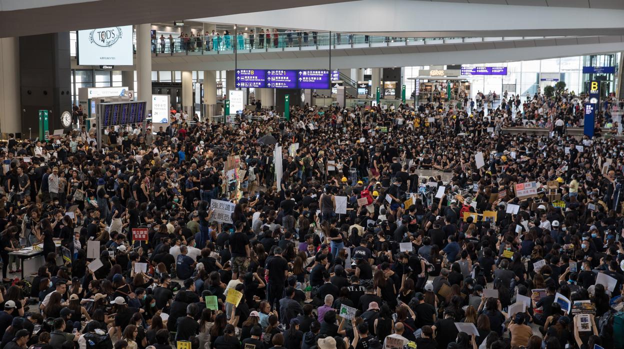 Manifestantes pro-democracia reciben a los pasajeros en el aeropuerto de Hong Kong