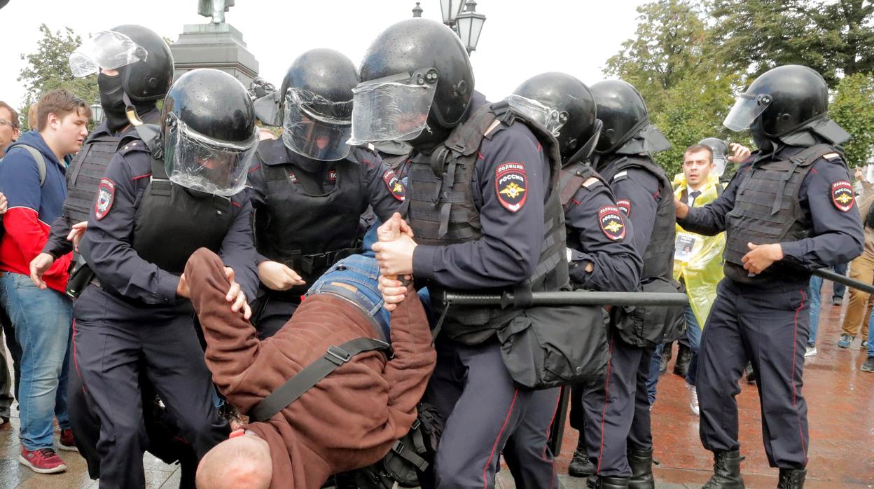 Varios policías antidisturbios se llevan en volandas a un manifestante durante una protesta opositora en el centro de Moscú