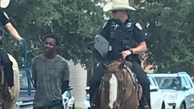 La polémica foto de dos policías a caballo en Texas que llevaban a un hombre negro esposado