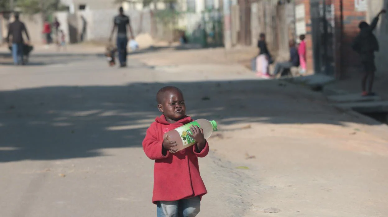 Un niño pequeño lleva una botella de agua en Harare. Zimbabue