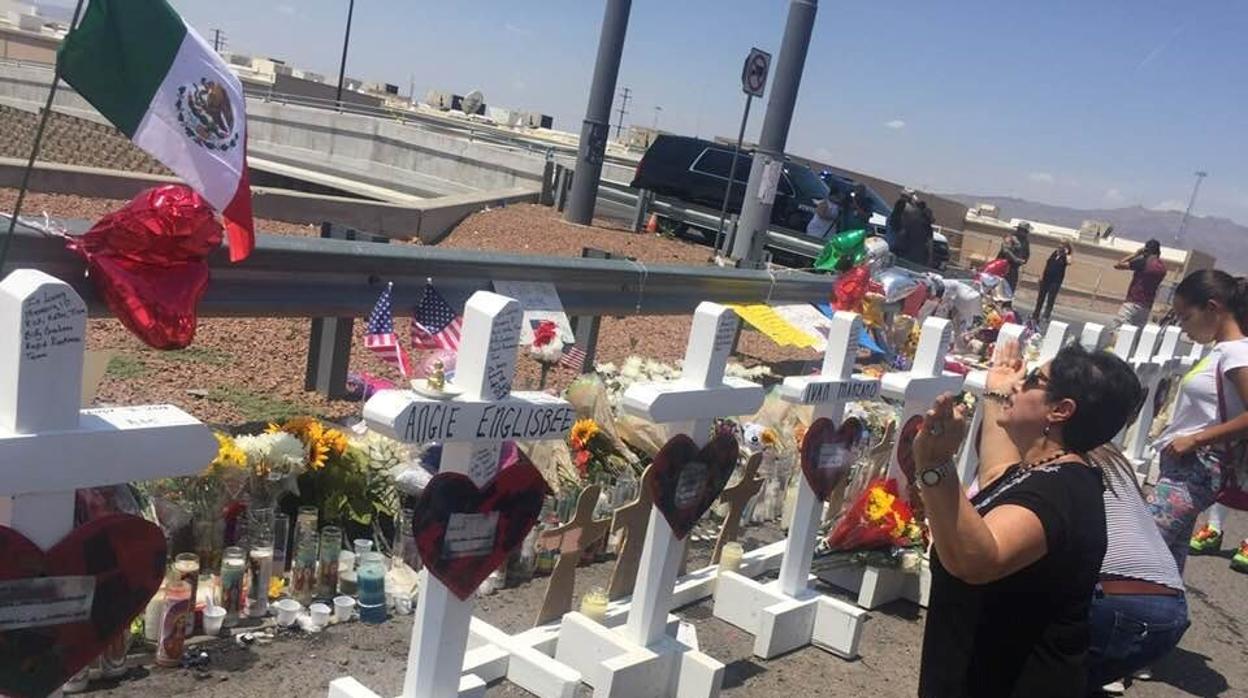 Una señora reza junto a las cruces que fueron colocadas frente a la tienda Walmart en El Paso
