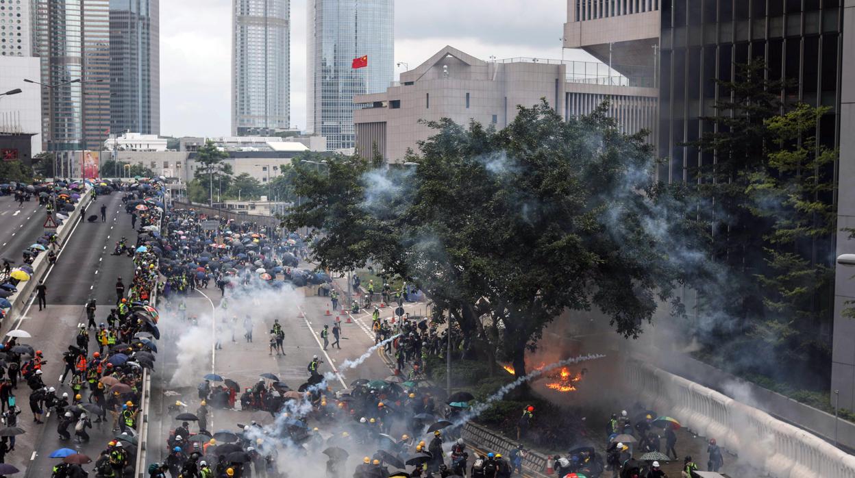 La policía lanza gases lagrimógenos contra los manifestantes. Uno de ellos ha arrojado momentos antes un cóctel molotov