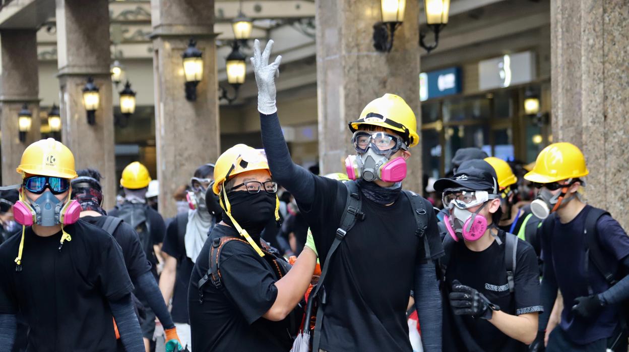 En primera línea de las barricadas, unas jóvenes insultan a la Policía antidisturbios