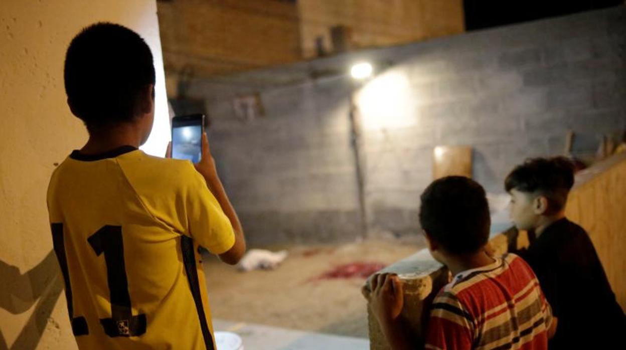 Niños observan la escena del tiroteo en el que un periodista de NatGeo recibió un disparo en la pierna