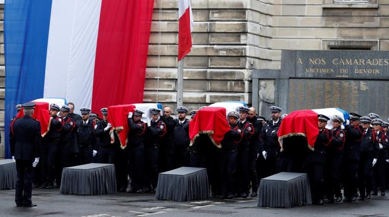 Agentes de la policía francesa cargan con varios ataúdes durante una ceremonia para rendir homenaje a las víctimas del ataque con cuchillo del pasado 3 de octubre