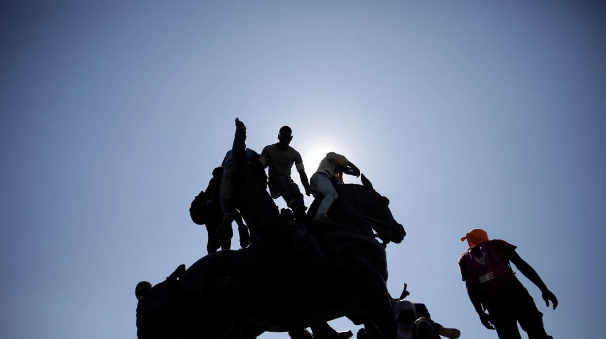 Manifestantes escalan la estatua del líder revolucionario Jean-Jacques Dessalines