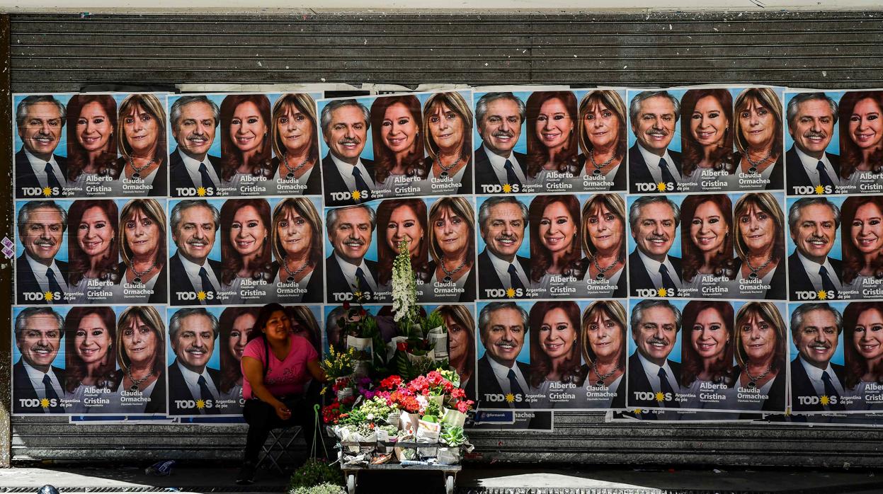 Una mujer vende flores bajo una propaganda política del candidato peronista a presidente de Argentina