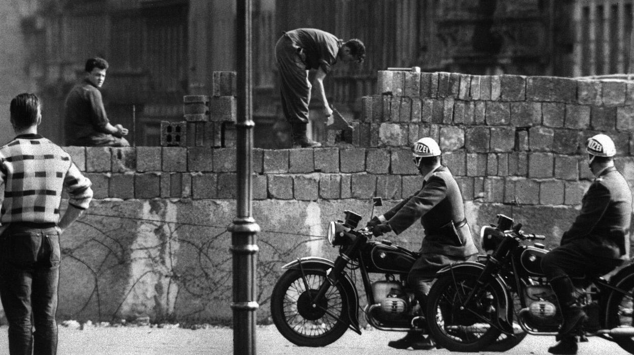 Fotografía de archivo tomada en agosto de 1961 que muestra a varios obreros levantando el muro en la calle Bernauer en Berlín