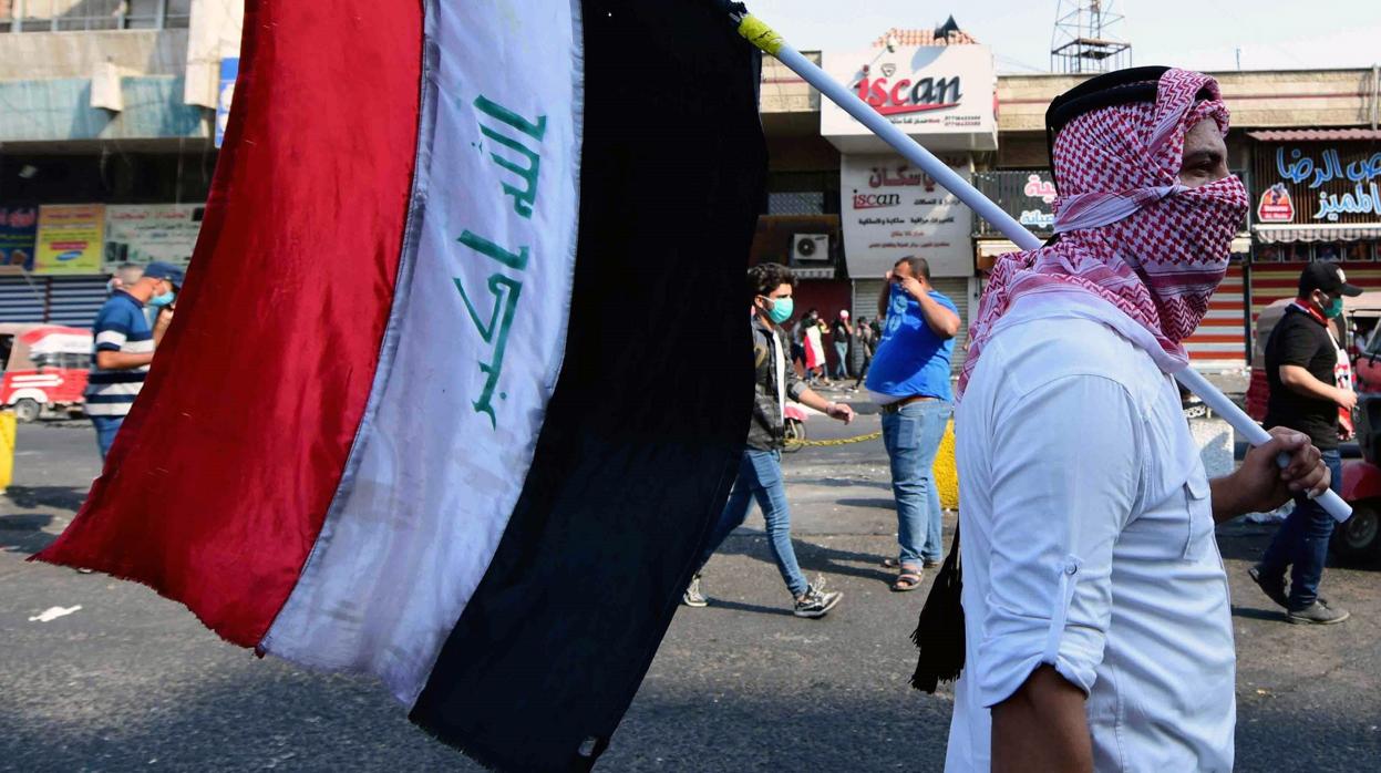 Un ciudadano iraquí porta una bandera de su país en las protestas