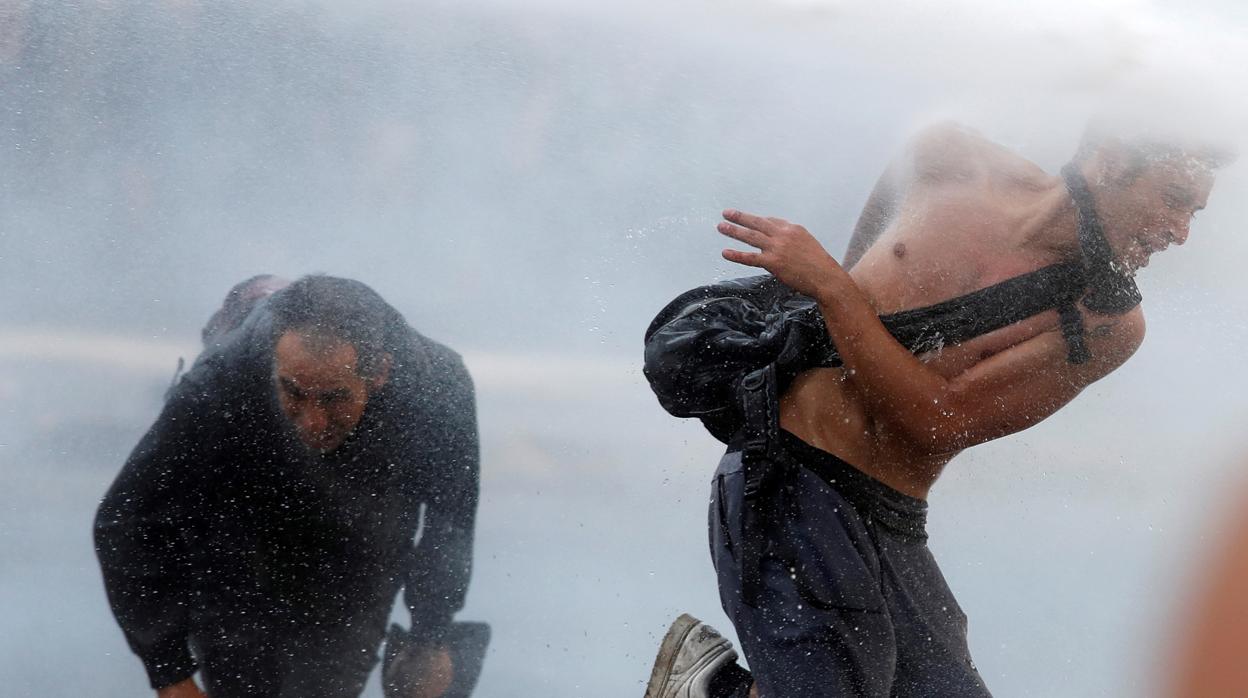 Los manifestantes huyen de un cañón de agua durante una protesta contra el gobierno de Chile en Santiago, Chile.