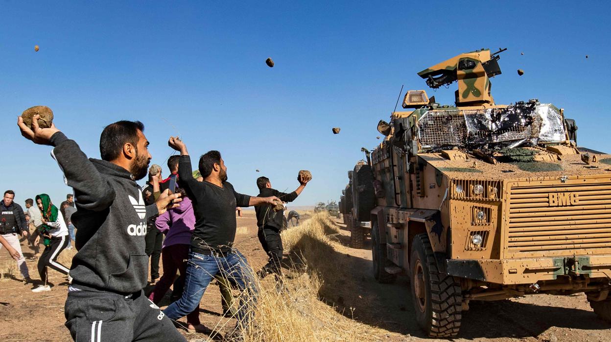 Manifestantes kurdo sirios lanzan piedras contra blindados turcos en el norte de Siria, hace un mes