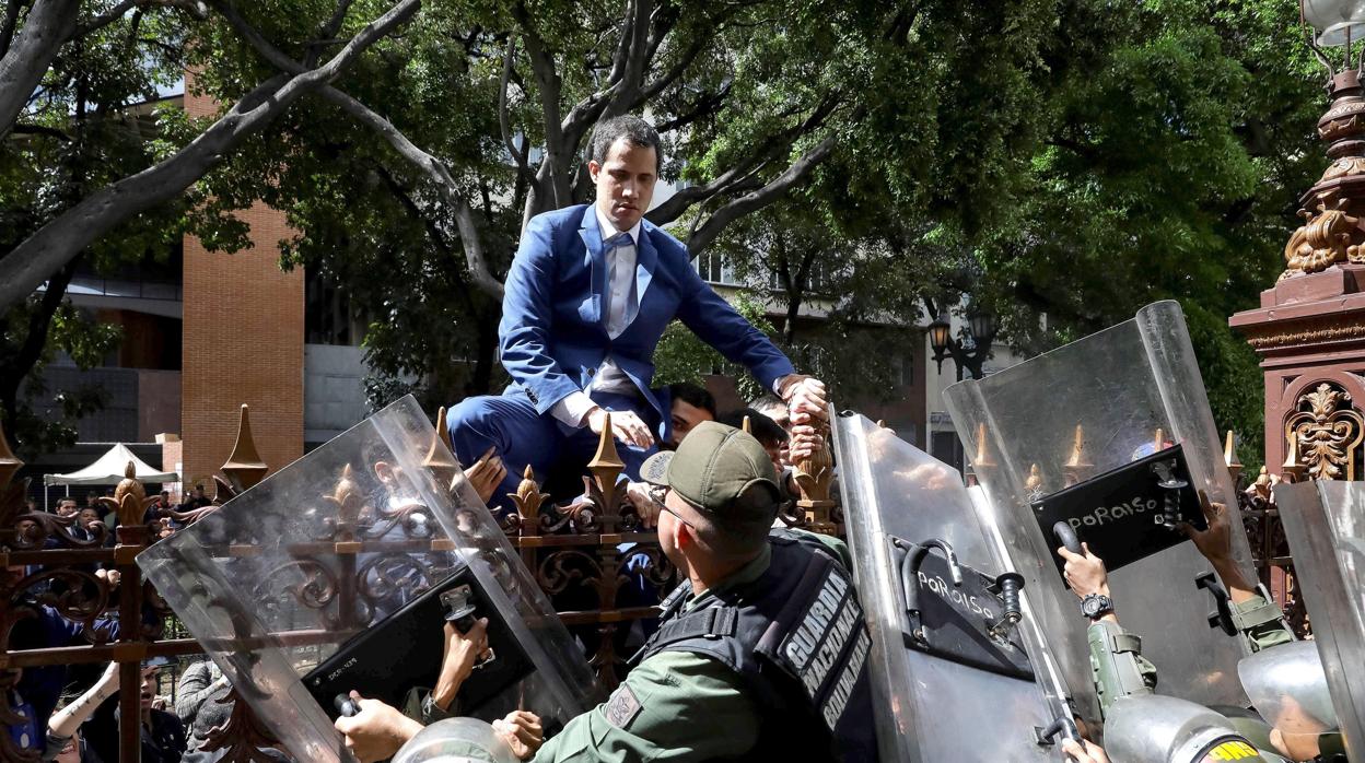 Juan Guaidó trepa a una verja en un intento por entrar a la sede de la Asamblea Nacional, en Caracas