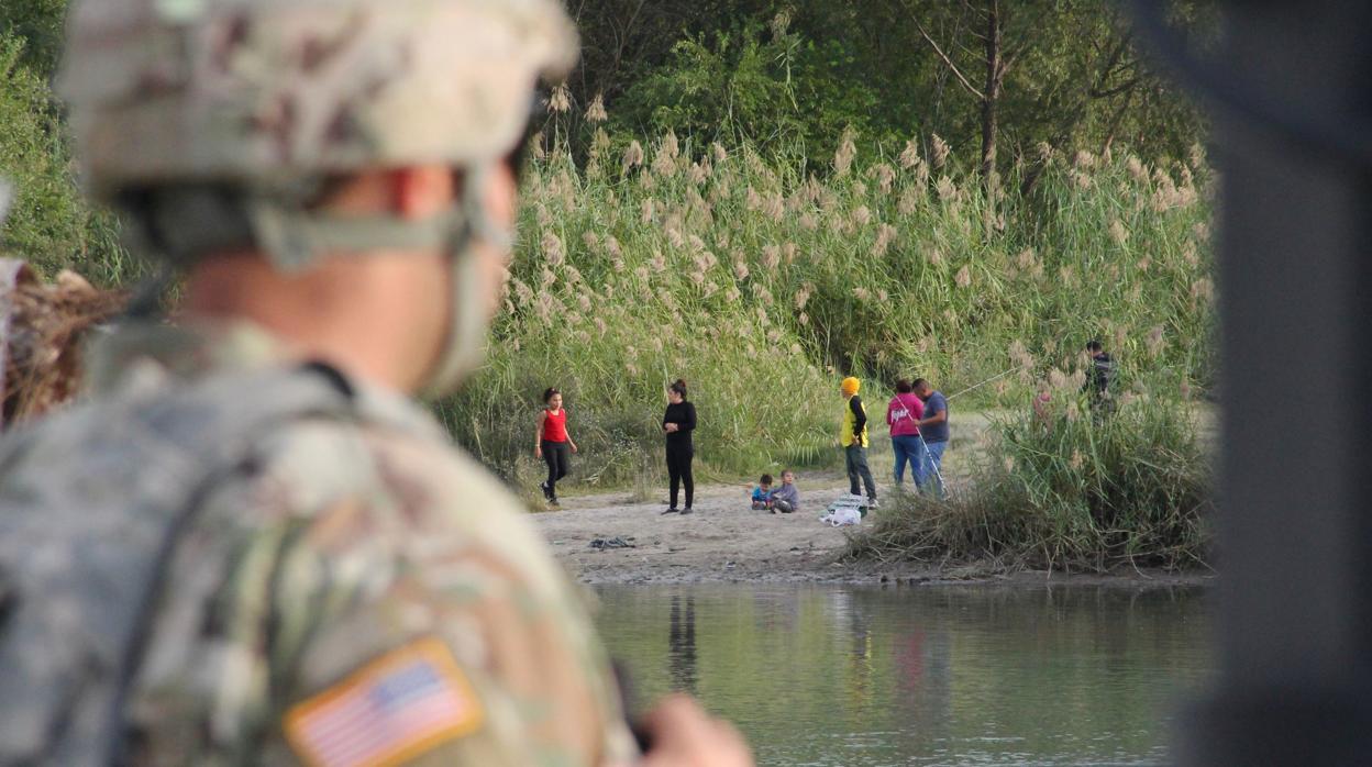 Un soldado norteamericano observa como un grupo de centroamericanos intentan cruzar el Río Grande