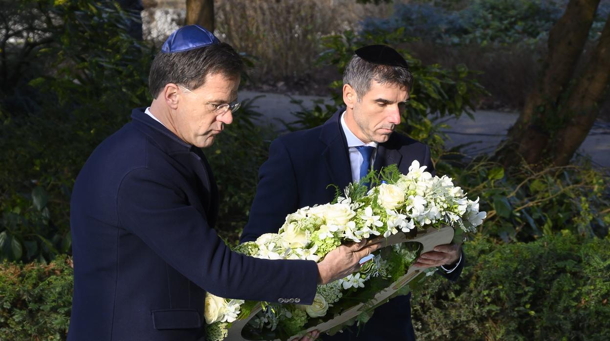 El Primer Ministro Mark Rutte (izq) y el Secretario de Estado Paul Blokhuis colocan una corona de flores en el monumento a Auschwitz en Ámsterdam