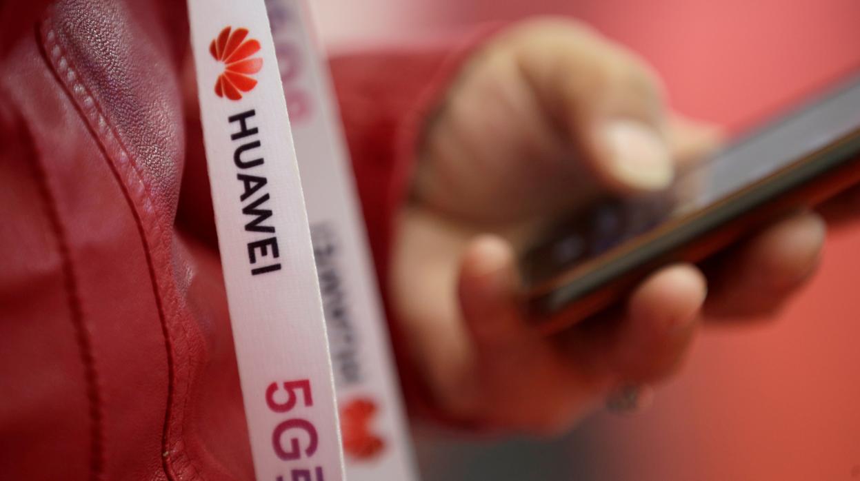 Un asistente lleva una tira de insignia con el logotipo de Huawei para la Exposición Mundial de 5G en Beijing