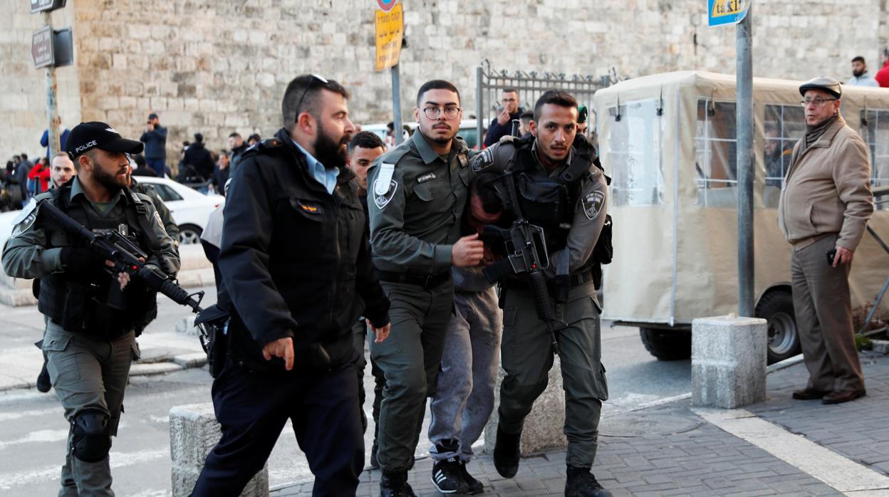 Las fuerzas de seguridad israelíes detienen a un palestino durante las protestas contra el plan de Trump, en la ciudad vieja de Jerusalén