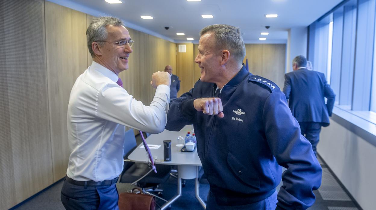 Stoltenberg y el general norteamericano Walters se saludan con los codos en la sede de la OTAN en Bruselas