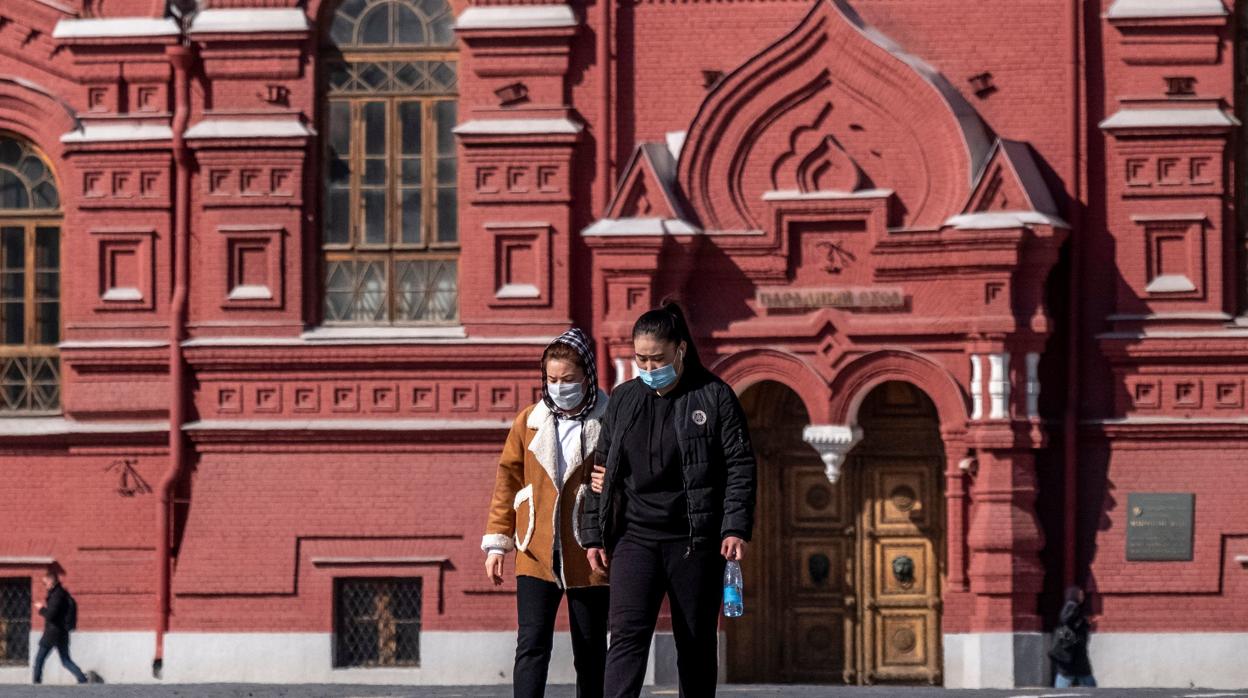 Dos mujeres caminan con mascarillas por Moscú