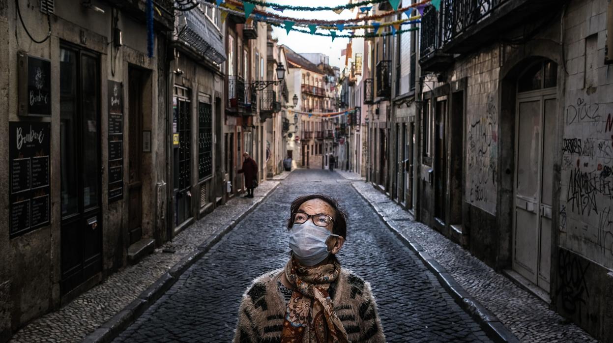 Una vecina del Barrio Alto de Lisboa regresa a casa tras hacer la compra