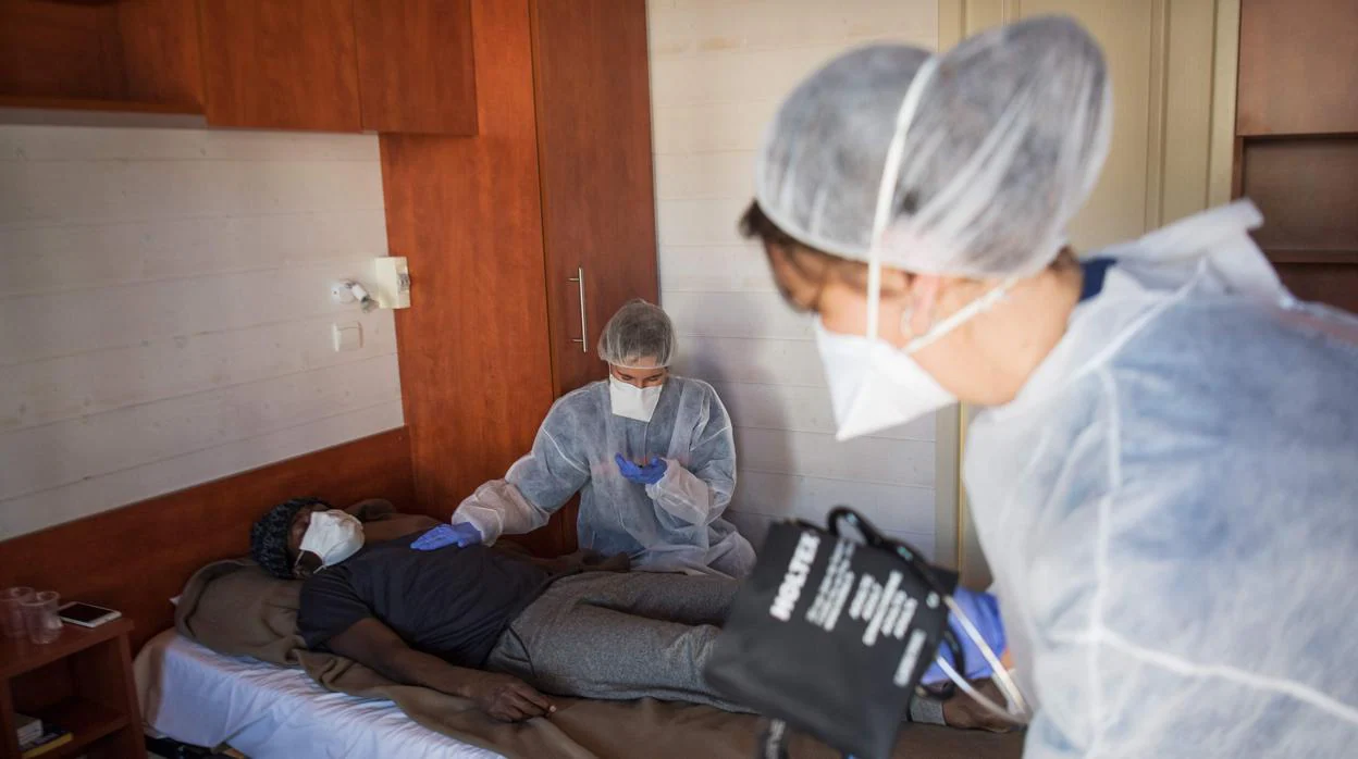 Personal sanitario examina a un inmigrante en Saint-Aignan-Grandlieu, en el oeste de Francia