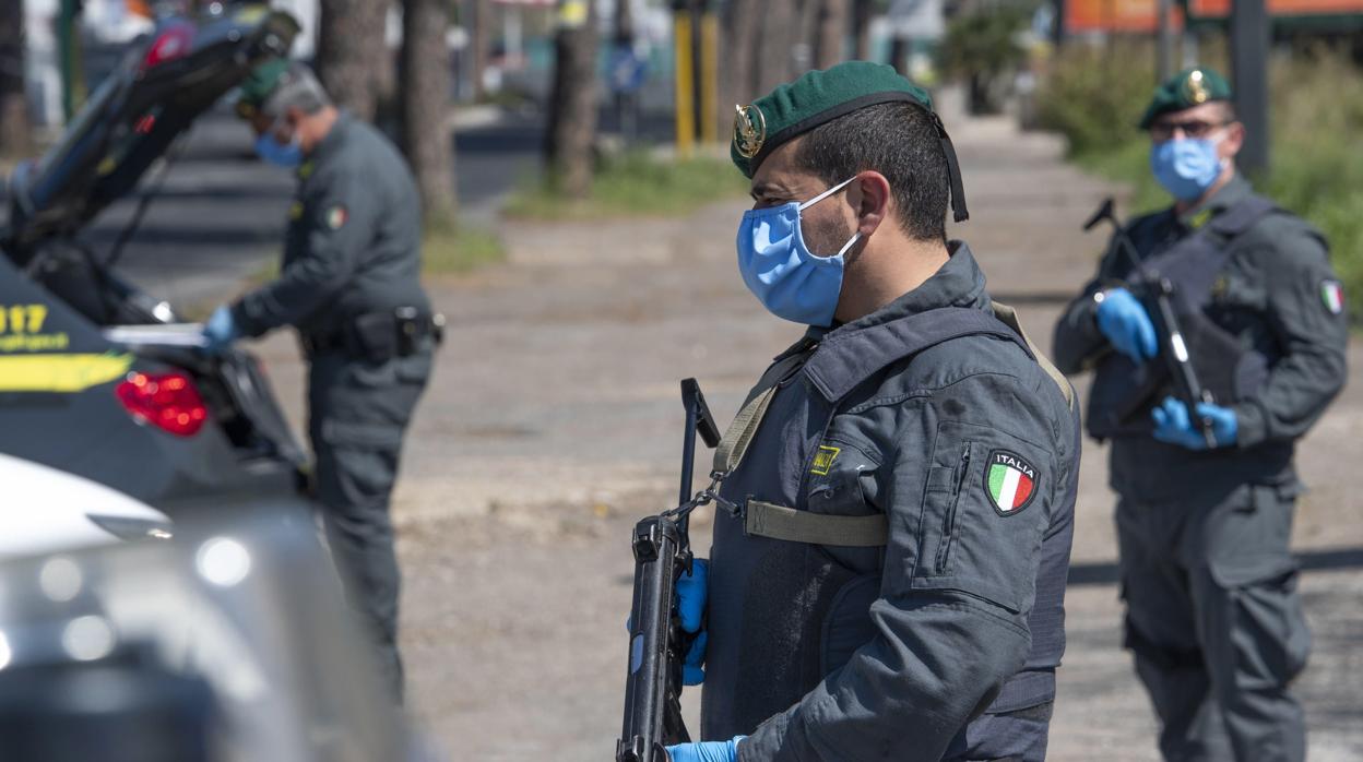 Miembros de la Guardia di Finanza vigilan los movimientos de quines abandonan Roma en Semana Santa en plena crisis del coronavirus