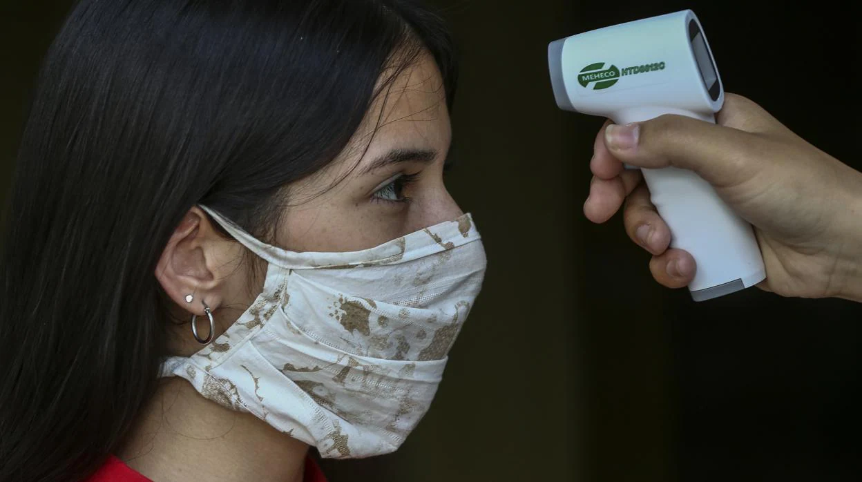 Una enfermera toma la temperatura a una joven en Caracas