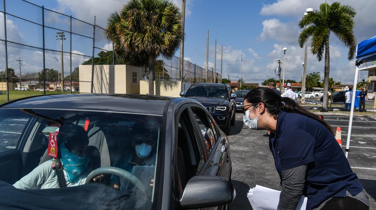 Fila de coches en Hialeah (Florida) para recoger solictudes de la ayuda del paro