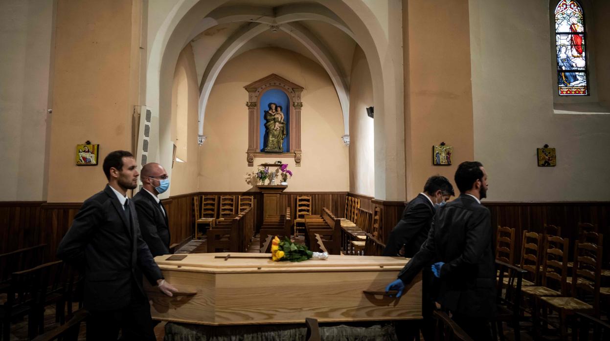 Miembros de una familia y un sacerdote asisten a una ceremonia fúnebre en una iglesia en Saint-Orens-de-Gameville, cerca de Toulouse