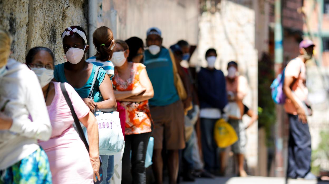 Varias mujeres hacen fila para recibir comida en Carapita