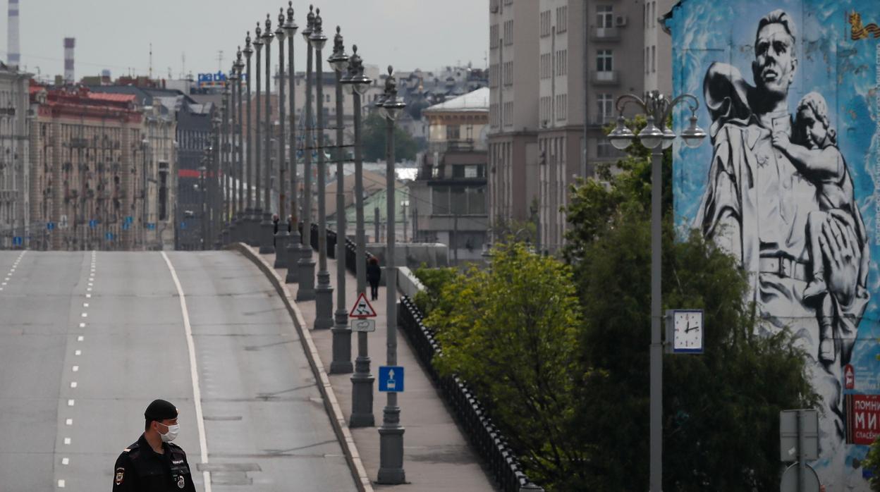 Un policía, protegido con una mascarilla, en una calle vacía de Moscú