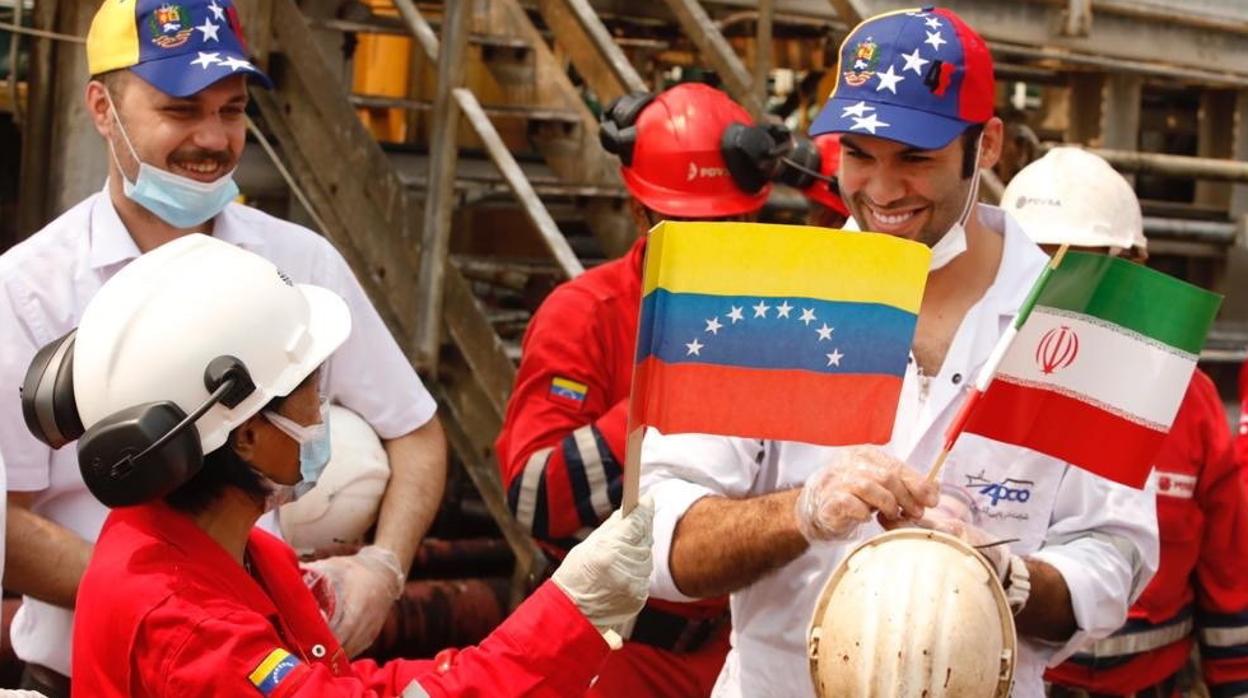 Trabajadores sostienen banderas de Irán y Venezuela en Puerto Cabello