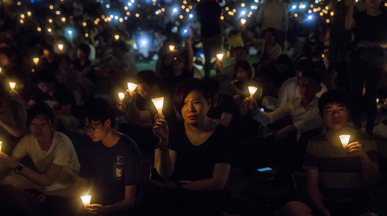Un grupo de personas sostiene velas durante la vigilia en Hong Kong del año pasado